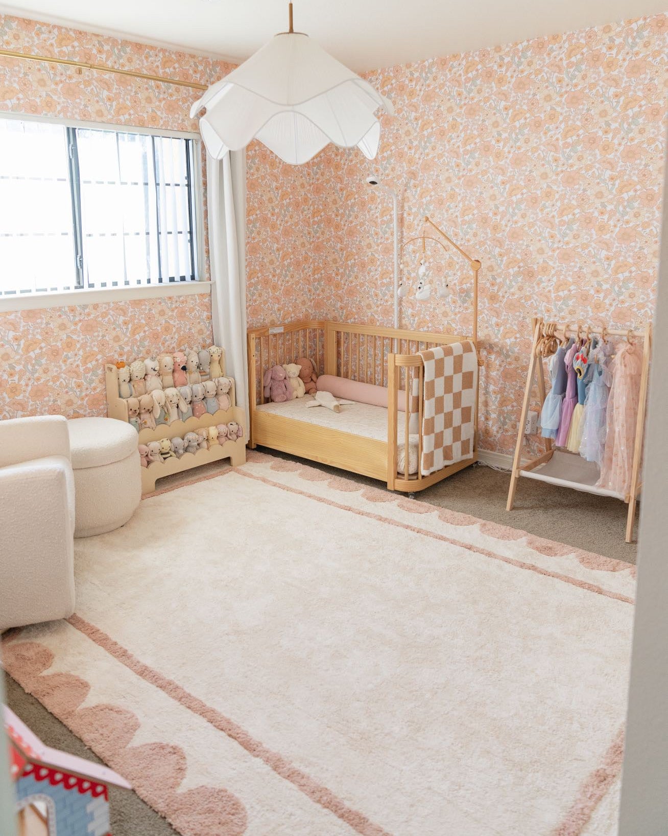 Nursery room with checkered crib, baby clothes, and decorative elements.